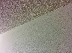 Angled photo of popcorn texture on the ceiling and knockdown on the walls