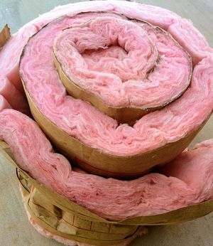 Photo of a roll of pink fiberglass insulation