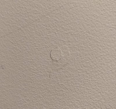 Picture of drywall cracking around a screw that has lost its holding power