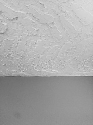 Foto di una spessa texture a secco a falco e cazzuola sul soffitto con pareti lisce